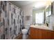 Bathroom featuring a shower/tub combo, neutral wall color, tiled floor and large mirror above the sink at 443 S Observatory Dr, Orlando, FL 32835