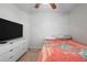 A cozy bedroom features a ceiling fan, a television, and a dresser at 443 S Observatory Dr, Orlando, FL 32835