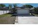 Charming single-story home featuring an attached two-car garage and well-maintained front yard at 443 S Observatory Dr, Orlando, FL 32835