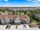 Aerial view highlighting a charming townhome community with beautiful landscaping, tile roofs, and convenient parking spaces at 4722 Terrasonesta Dr, Davenport, FL 33837