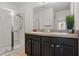 Bathroom featuring double sinks, vanity, a large mirror, and a glass-enclosed shower at 4722 Terrasonesta Dr, Davenport, FL 33837