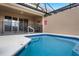 Inviting private pool area with a safety fence, covered patio, and comfortable seating for relaxation and outdoor enjoyment at 4722 Terrasonesta Dr, Davenport, FL 33837