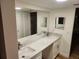 Well-lit bathroom featuring a double vanity with a marble countertop, large mirrors, and ample cabinet space at 500 Newell Hill Rd # 109A, Leesburg, FL 34748