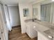 Bathroom featuring a dual-sink vanity with a marble countertop, a vanity mirror, and ample cabinet space at 500 Newell Hill Rd # 109A, Leesburg, FL 34748