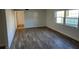 Living room with wood look floors and a large window for natural light at 500 Newell Hill Rd # 109A, Leesburg, FL 34748