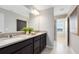 Spacious bathroom with dual sinks, dark wood cabinetry, large mirror, and access to a walk-in shower at 5044 Starling Bird Ln, St Cloud, FL 34771