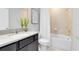 Well-lit bathroom featuring a single vanity, tub and shower combo with tiled walls and decorative plant at 5044 Starling Bird Ln, St Cloud, FL 34771