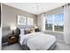 Well-lit bedroom with a large window, comfortable bed, stylish lighting, and decorative wall art at 5044 Starling Bird Ln, St Cloud, FL 34771