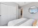Cozy bedroom with large closet, comfortable bed with grey and white linens and unique geometric mirror at 5044 Starling Bird Ln, St Cloud, FL 34771