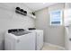 Well-lit laundry room with modern washer and dryer, plus ample shelving for storage at 5044 Starling Bird Ln, St Cloud, FL 34771