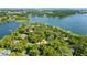 Scenic aerial view of waterfront homes surrounded by lush greenery and a lake at 5100 Cranes Point Ct, Orlando, FL 32839