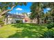 Lush backyard with mature trees and manicured lawn surrounding the home's exterior at 5100 Cranes Point Ct, Orlando, FL 32839