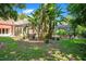 Landscaped backyard featuring tropical foliage and a screened-in patio with seating area at 5100 Cranes Point Ct, Orlando, FL 32839