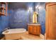 Bathroom featuring blue textured walls, soaking tub, and a wood vanity at 5100 Cranes Point Ct, Orlando, FL 32839