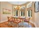 Elegant dining room with bay windows, wood floors, decorative rug, and an ornate chandelier at 5100 Cranes Point Ct, Orlando, FL 32839
