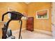 Home exercise area featuring a treadmill, windows, and a wooden storage cabinet at 5100 Cranes Point Ct, Orlando, FL 32839