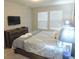 Comfortable bedroom featuring a large bed, dresser, and two windows for natural light at 5123 Crown Haven Dr, Kissimmee, FL 34746
