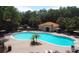 Aerial view of a large community pool with lounge chairs and umbrellas surrounded by mature trees at 5123 Crown Haven Dr, Kissimmee, FL 34746