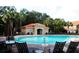 View of the pool area featuring a clubhouse, lounge chairs, and mature palm trees at 5123 Crown Haven Dr, Kissimmee, FL 34746