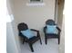 Close up view of two chairs with patterned throw pillows on a cozy front porch at 5123 Crown Haven Dr, Kissimmee, FL 34746