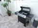 Modern stainless steel grill with side burner on a paver patio near an outdoor trash can at 5123 Crown Haven Dr, Kissimmee, FL 34746