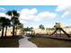 Community playground area featuring a slide and gazebo, surrounded by sidewalks, palm trees, and townhomes at 5123 Crown Haven Dr, Kissimmee, FL 34746