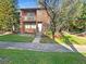 Two-story brick building with a balcony, front yard, and mature trees at 5126 Picadilly Circus Ct # 11, Orlando, FL 32839