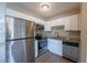 Well-lit kitchen with stainless steel appliances, white cabinets, and granite countertops at 5600 Arundel Dr, Orlando, FL 32808