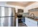 Bright kitchen featuring stainless steel appliances, granite countertops, and white cabinets at 5600 Arundel Dr, Orlando, FL 32808
