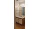 Bathroom featuring a sink with white countertop, wooden laminate floor, and a large mirror at 625 Dory Ln # 204, Altamonte Springs, FL 32714