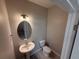 Cozy powder room featuring a pedestal sink and oval mirror with modern lighting at 628 Pothos St, Apopka, FL 32703