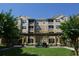Beautiful condo with well-manicured lawn and a golf cart in the covered area in front of the building at 6434 Cava Alta Dr # 303, Orlando, FL 32835