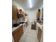 Efficient kitchen with tile floor, wooden cabinets, and white appliances at 6434 Cava Alta Dr # 303, Orlando, FL 32835