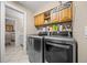 Laundry room featuring modern washer and dryer units with storage shelving at 677 Benitawood Ct, Winter Springs, FL 32708