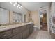 This main bathroom has dual sinks with a granite countertop and a large mirror, as well as a walk-in shower at 677 Benitawood Ct, Winter Springs, FL 32708