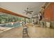 Covered lanai and outdoor kitchen area with bar seating overlooking the screened pool at 677 Benitawood Ct, Winter Springs, FL 32708
