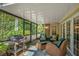 Cozy screened porch with comfortable seating, outdoor grill, and serene views of the surrounding landscape at 677 Benitawood Ct, Winter Springs, FL 32708