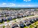 Aerial view showcases a home with lawn in a neighborhood near a lake and wetlands at 7649 Ragusa Way, Clermont, FL 34714