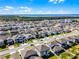 Aerial view of a neighborhood with manicured lawns, modern houses and community near a lake and wetlands at 7649 Ragusa Way, Clermont, FL 34714