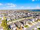 An aerial perspective captures a community near a lake, featuring modern homes with yards and professional landscaping at 7649 Ragusa Way, Clermont, FL 34714