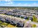 Aerial view displaying a new home community with modern houses and well-maintained landscapes under a blue sky at 7649 Ragusa Way, Clermont, FL 34714