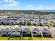 An aerial view highlights a home and lawn in a well-planned community with a nearby lake and wetlands at 7649 Ragusa Way, Clermont, FL 34714