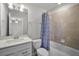 Bathroom features a tiled shower with a shower curtain and modern vanity at 7649 Ragusa Way, Clermont, FL 34714