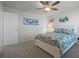 Charming bedroom with tropical wall art and a bright ceiling fan and light fixture at 7649 Ragusa Way, Clermont, FL 34714