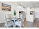 Breakfast nook with glass table, wicker chairs, and open to the modern kitchen at 7649 Ragusa Way, Clermont, FL 34714