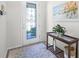 Charming entryway featuring a glass-paneled door, stylish table and beach-themed wall art at 7649 Ragusa Way, Clermont, FL 34714
