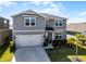 Attractive two-story home featuring a landscaped front yard, a two-car garage, and a welcoming entrance at 7649 Ragusa Way, Clermont, FL 34714
