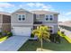 Eye-catching two-story home with a lovely lawn, delightful landscaping, and a practical two-car garage at 7649 Ragusa Way, Clermont, FL 34714