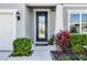 The front entry showcases a decorative glass door framed by manicured greenery at 7649 Ragusa Way, Clermont, FL 34714