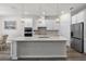 Bright, white kitchen with stainless steel appliances, large island with sink and breakfast bar at 7649 Ragusa Way, Clermont, FL 34714